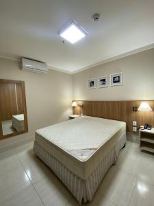 um quarto com uma cama grande num quarto em Caldas Novas - Piazza diRoma incluso acesso ao Acqua Park, Slplash e Slide em Caldas Novas