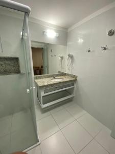 W łazience znajduje się prysznic, umywalka i lustro. w obiekcie Caldas Novas - Piazza diRoma incluso acesso ao Acqua Park, Slplash e Slide w mieście Caldas Novas