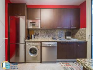 uma cozinha com um frigorífico e uma máquina de lavar roupa em Casa Ànima em Platja d'Aro