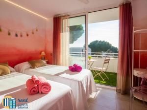 a room with two beds with pink towels on them at Casa Ànima in Platja  d'Aro