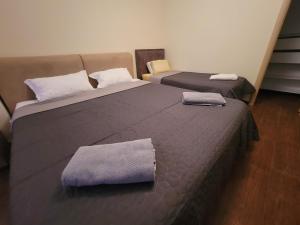 ein Schlafzimmer mit 2 Betten und Handtüchern darauf in der Unterkunft Spacious and Cozy Apartment in Tirana