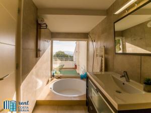 a bathroom with a tub and a sink and a mirror at Casa Anima en Platja d'Aro in Platja d'Aro +18 photos