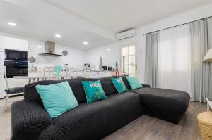 uma sala de estar com um sofá preto com almofadas azuis em YourHouse Es Pla Cycling House em Maria de la Salut