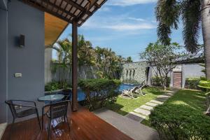 a patio with a table and chairs and a pool at VILLA ATA | Private Pool | Saiyuan Estate by Tropiclook | Nai harn beach in Nai Harn Beach