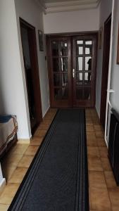 Hársfaapartman és vendégház في غيولا: ممر فيه باب خشبي وسجادة سوداء