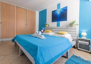 1 dormitorio con 2 camas, paredes azules y un colchón azul en Gwad'AZUR - séjour tout confort en Guadeloupe en Le Gosier