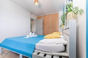 1 dormitorio con 1 cama con sábanas azules y almohadas amarillas en Gwad'AZUR - séjour tout confort en Guadeloupe en Le Gosier