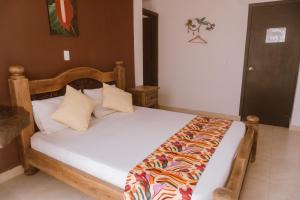 um quarto com uma cama e uma cabeceira em madeira em Tuki Hostel & Lounge em Pereira