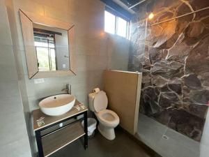 een badkamer met een wastafel, een toilet en een douche bij Departamento María in Baños