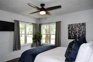a bedroom with a ceiling fan and two windows at The Mayor in Gore in Gore