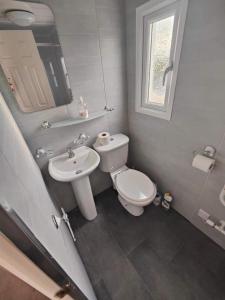 a white bathroom with a toilet and a sink at MILLFIELDS AT INGOLDMELLS, Skegness in Tattershall