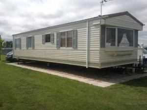 een witte trailer is geparkeerd in een veld bij MILLFIELDS AT INGOLDMELLS, Skegness in Tattershall