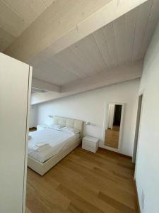 una camera con letto bianco e pavimento in legno di WATERFRONT a Montesilvano