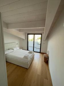 1 dormitorio con 1 cama blanca grande y suelo de madera en WATERFRONT, en Montesilvano