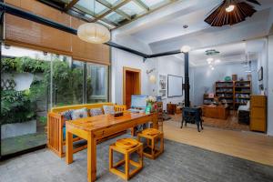 Dali Buxianshan Boutique Guesthouse في دالي: غرفة معيشة مع طاولة خشبية وأريكة