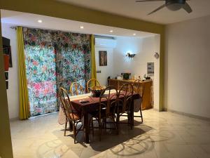 una sala da pranzo con tavolo e sedie e una cucina di Villa bonheur Somone a Somone