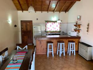 eine Küche mit einer Theke und Hockern in einem Zimmer in der Unterkunft Casa Elena in Villa Gesell