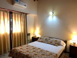 ein Schlafzimmer mit einem Bett und zwei Lampen und einem Fenster in der Unterkunft Casa Elena in Villa Gesell