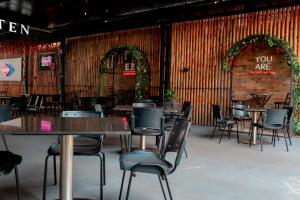 a dining room with tables and chairs and a brick wall at Megal Suites Hotel in Ciudad del Este