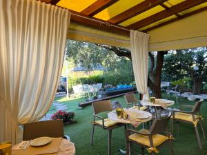 a patio with tables and chairs in a yard at Garda Dream in Lazise