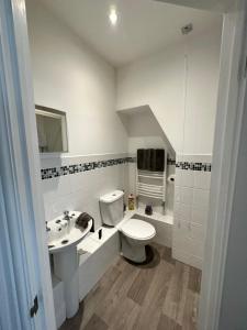 a white bathroom with a toilet and a sink at The Lookout, Bridlington in Bridlington