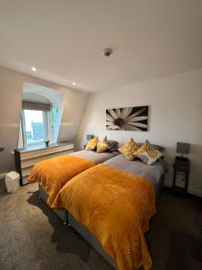 a bedroom with a large bed with an orange blanket at The Lookout, Bridlington in Bridlington