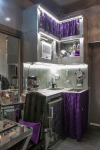 eine Küche mit lila Vorhängen an den Schränken und einem Waschbecken in der Unterkunft Jacuzzi Love SuiteSweetRome in Rom