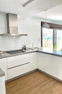 a white kitchen with white cabinets and a sink at LA MESA in Félix