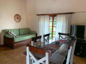 ein Wohnzimmer mit einem Tisch und einer grünen Couch in der Unterkunft Casa Elena in Villa Gesell