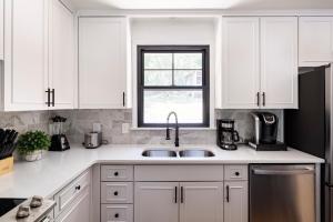 納許維爾的住宿－Spacious Home In A Quiet Neighborhood，厨房配有白色橱柜、水槽和窗户。
