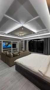 Hotel Panorama في دوسهانبي: غرفة نوم كبيرة مع سرير كبير وأريكة