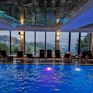 a pool in a hotel with chairs and a view at Lola apartman Milmari & Residence Hill in Kopaonik