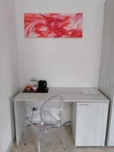 een bureau met een stoel en een schilderij aan de muur bij MAWA in Ferrara