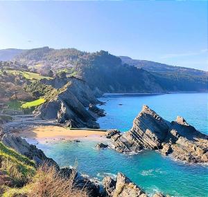 een uitzicht op een strand met rotsen en de oceaan bij Arrantzale Beach in Bermeo