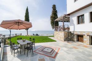 a patio with a table and chairs and an umbrella at Mermaid Villa & Apartment Common Areas in Koropi