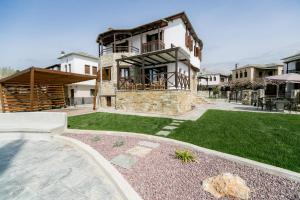 a large house with a patio and a yard at Mermaid Villa & Apartment Common Areas in Koropi