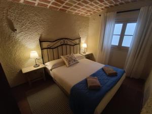 een slaapkamer met een groot bed en 2 handdoeken bij Casa Peratallada in Peratallada