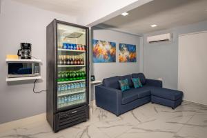 una camera con un refrigeratore per bevande e un divano blu di Casas acogedoras en Bahia Azul a Cancún