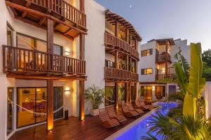 an exterior view of a building with chairs and a pool at Aparthotel Onda Maya - Adults Only in Holbox Island