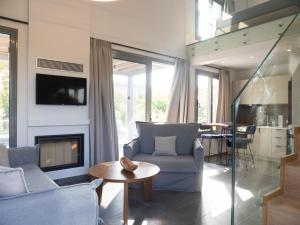 a living room with a couch and a fireplace at Sea breeze suites Mistral 4 per with private pool in Kandia