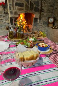 uma mesa com um prato de pão e um copo de vinho em Guest House BOZVILL em Bozovec
