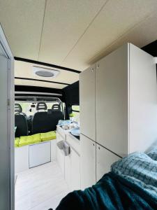 an rv with white cabinets and a kitchen with at On Road- feel freedom with campervan! in El Guincho