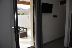 a room with a sliding glass door with a television at B&B Il Sole in Castelluzzo