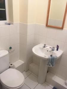 a white bathroom with a toilet and a sink at Lovely Two bed flat located in the heart of Dunstable in Dunstable