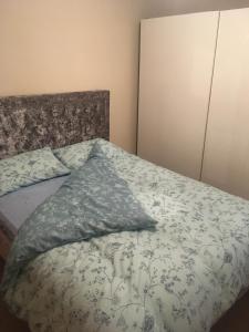 a bed with a blanket and pillows on it at Lovely Two bed flat located in the heart of Dunstable in Dunstable