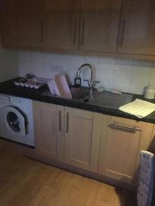 a kitchen with a sink and a washing machine at Lovely Two bed flat located in the heart of Dunstable in Dunstable