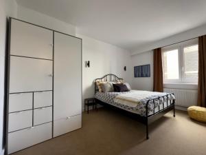 um quarto com uma cama e um grande armário branco em La Suite 108 em Rouen