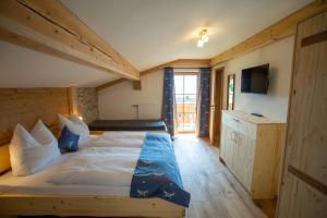 um quarto com uma cama grande e uma televisão em Ramslerhof - Chiemgau Karte em Inzell