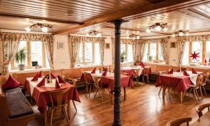 Gasthof zum Rößle Lautrach في Lautrach: مطعم فيه طاولات وكراسي في الغرفة