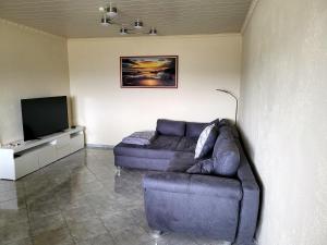 a living room with a couch and a flat screen tv at schöne, modernisierte Wohnung - Dudweiler in Saarbrücken